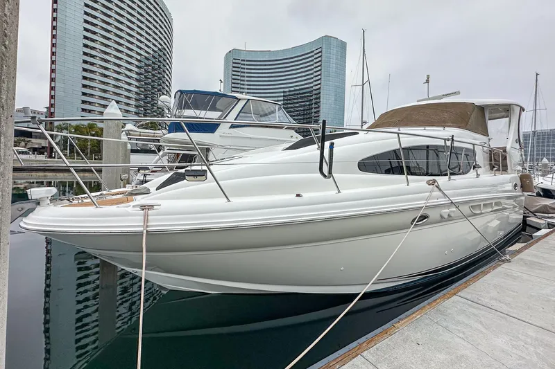Pan-a-sea-ahh Yacht Photos Pics 2004 Sea Ray 390 Motor Yacht docked at marina, modern buildings in background.
