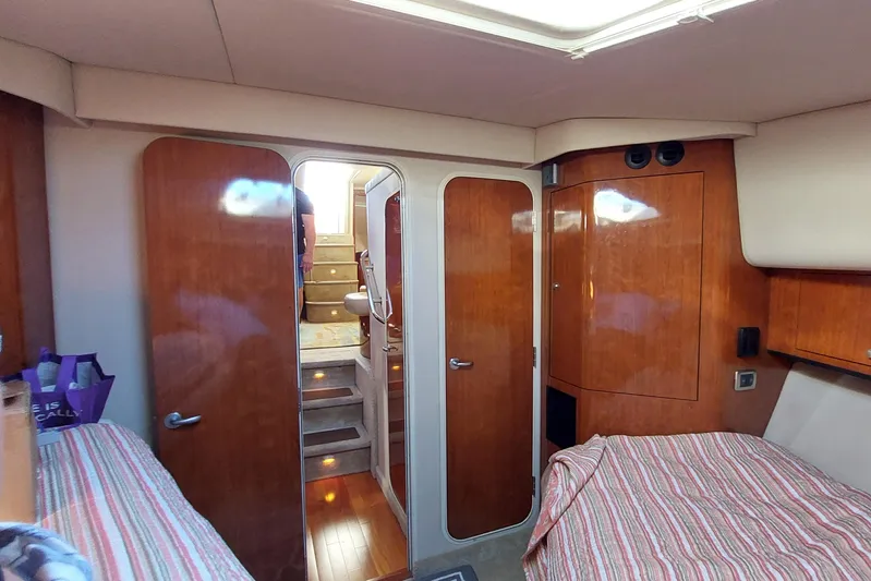 Pan-a-sea-ahh Yacht Photos Pics Interior of 2004 Sea Ray 390 Motor Yacht with wood paneling and striped bedding.