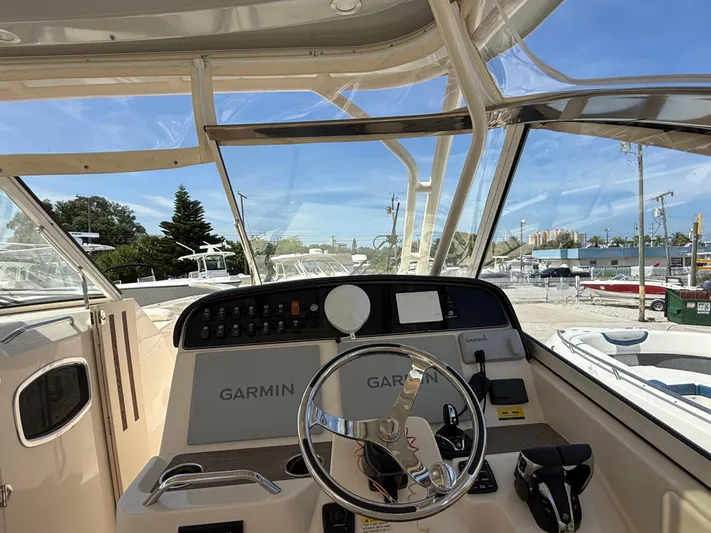 335-514 Brokerage Ron Yacht Photos Pics 2023 Grady-White Freedom 335 boat helm with Garmin navigation system, docked under clear blue sky.