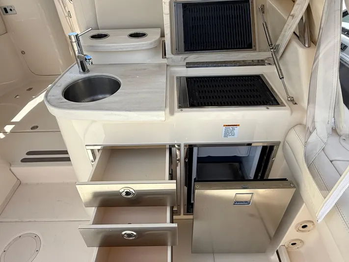 335-514 Brokerage Ron Yacht Photos Pics 2023 Grady-White Freedom 335 boat kitchen with sink, grill, and storage drawers.