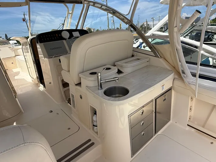 335-514 Brokerage Ron Yacht Photos Pics 2023 Grady-White Freedom 335 boat interior with helm, sink, and storage drawers.