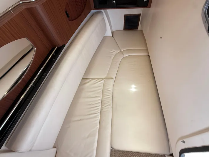 335-514 Brokerage Ron Yacht Photos Pics 2023 Grady-White Freedom 335 interior cabin with white leather seating and wood accents.
