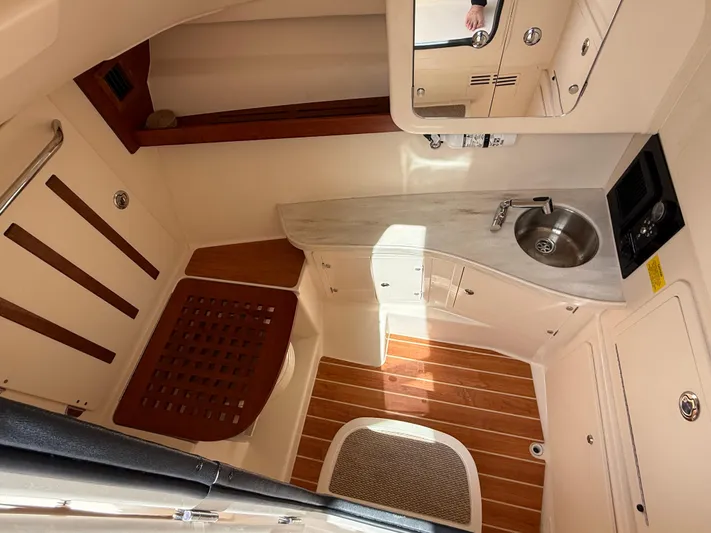335-514 Brokerage Ron Yacht Photos Pics 2023 Grady-White Freedom 335 cabin interior with sink and wooden flooring.