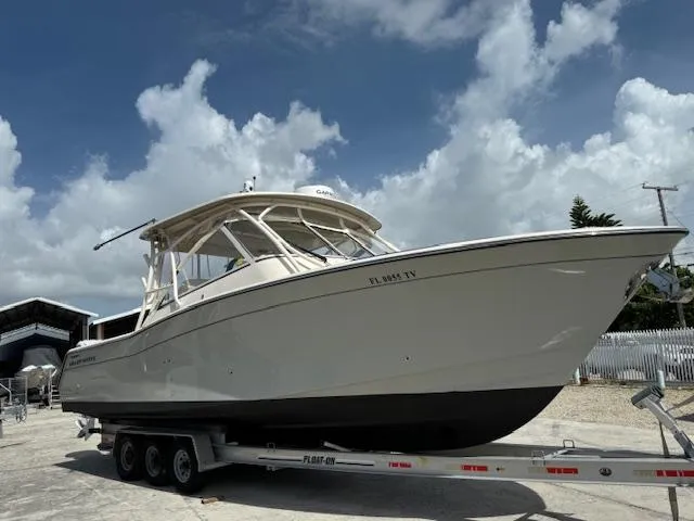 335-514 Brokerage Ron Yacht Photos Pics 2023 Grady-White Freedom 335 boat on trailer under cloudy sky.