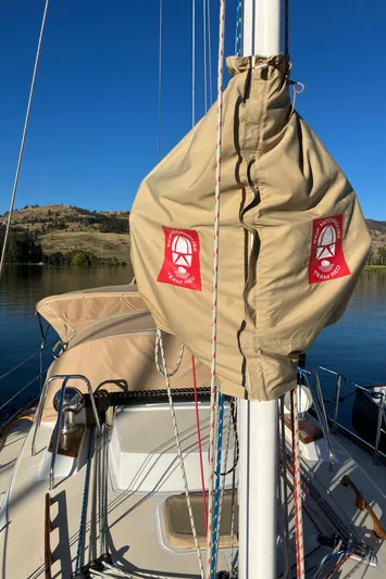 Celebration Yacht Photos Pics 2007 Tartan 3400 sailboat with beige sail cover, docked on a serene lake.