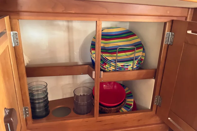Celebration Yacht Photos Pics Wooden cabinet with colorful striped plates and glasses, Tartan 3400, 2007 model.