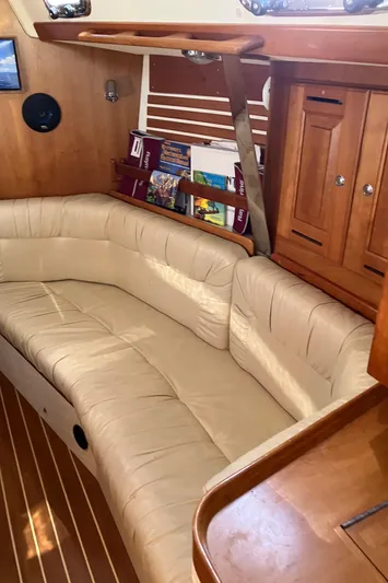 Celebration Yacht Photos Pics Interior of a 2007 Tartan 3400 sailboat with beige seating and wooden cabinetry.