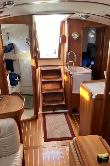 Celebration Yacht Photos Pics Interior of 2007 Tartan 3400 sailboat with wooden finishes and compact kitchen area.
