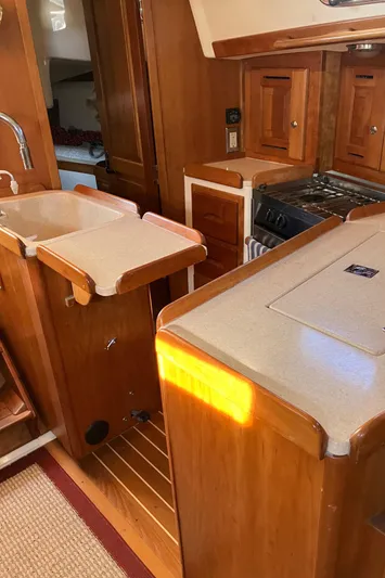 Celebration Yacht Photos Pics 2007 Tartan 3400 yacht interior with wooden cabinetry and kitchen area.