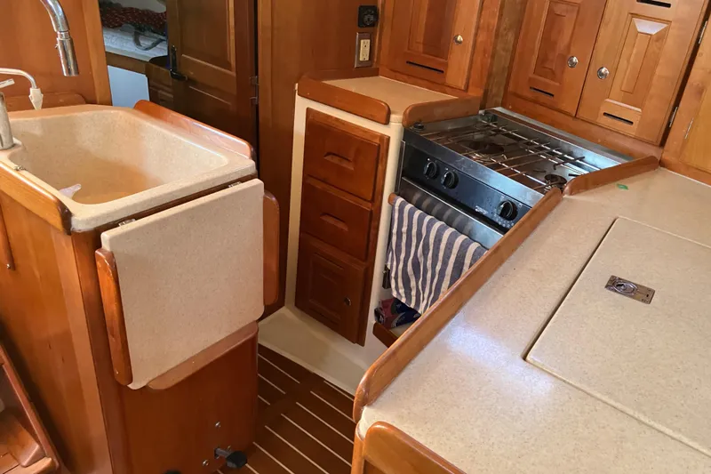 Celebration Yacht Photos Pics 2007 Tartan 3400 yacht kitchen with wooden cabinetry and compact appliances.