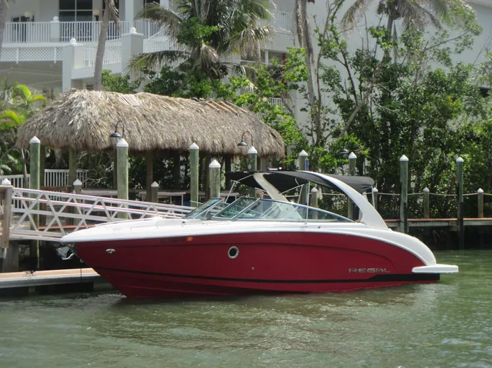  Yacht Photos Pics 2017 Regal 3200 Bowrider boat docked by a tropical waterfront.