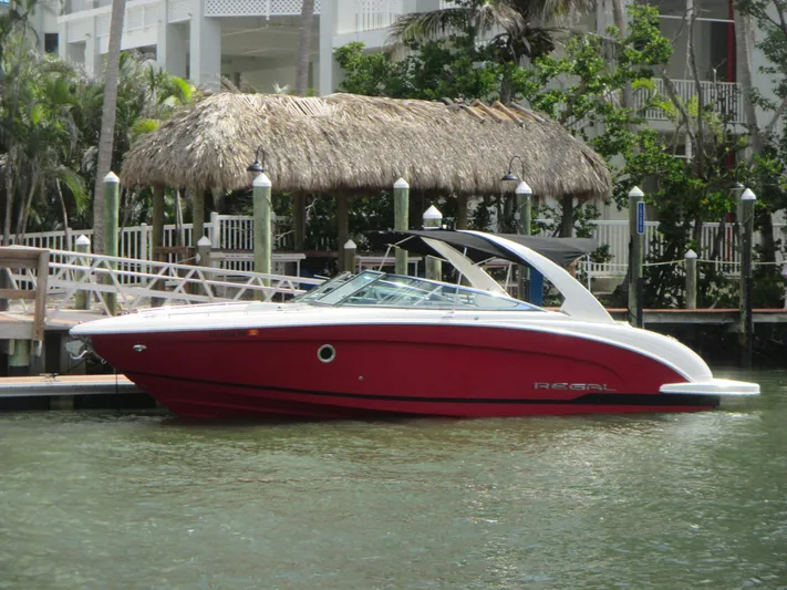  Yacht Photos Pics 2017 Regal 3200 Bowrider boat docked by tropical waterfront.