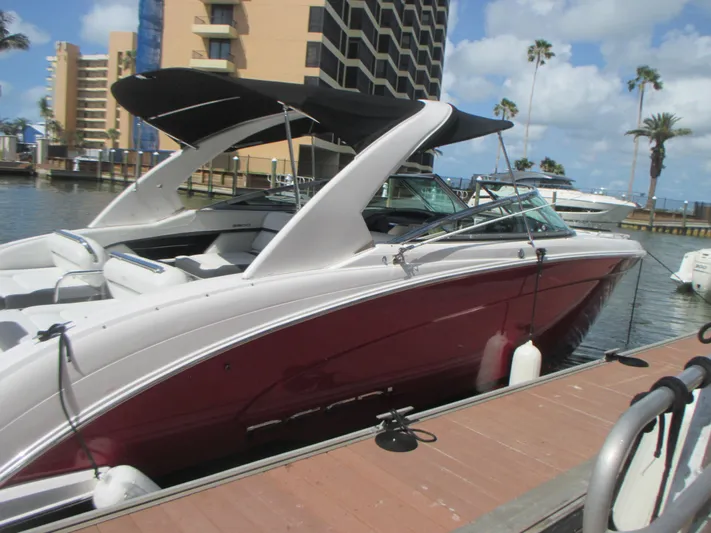  Yacht Photos Pics 2017 Regal 3200 Bowrider boat docked, featuring sleek design and maroon hull.