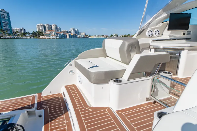  Yacht Photos Pics 2023 Tiara Yachts 34 LX on calm waters with cityscape view.