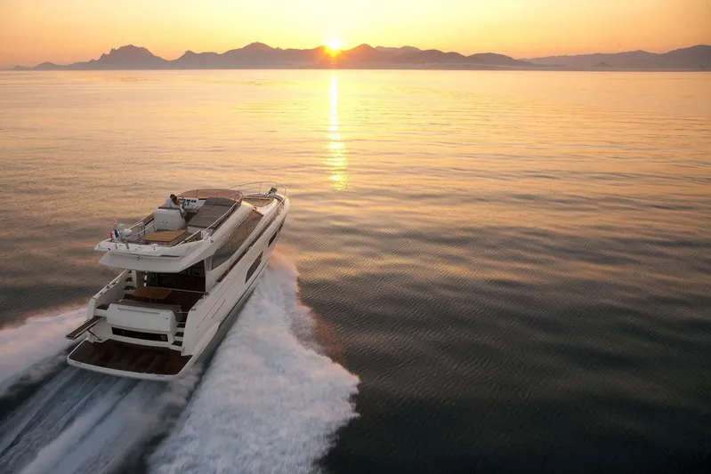  Yacht Photos Pics Prestige 550 Fly yacht cruising at sunset, 2014 model, serene ocean view.
