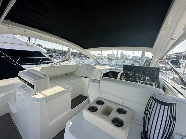 Lux Life Yacht Photos Pics 2017 Cruisers Yachts 390 Express Coupe interior with seating and helm, docked at marina.