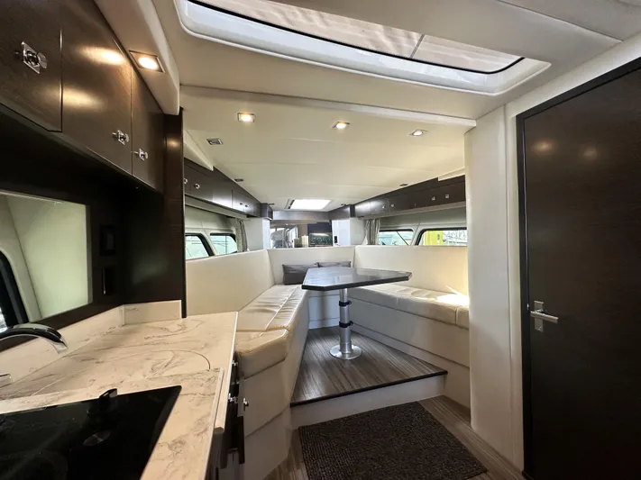 Lux Life Yacht Photos Pics Luxurious interior of 2017 Cruisers Yachts 390 Express Coupe with modern seating and dining area.