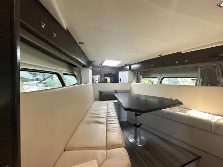 Lux Life Yacht Photos Pics Luxurious interior of 2017 Cruisers Yachts 390 Express Coupe with elegant seating and table.