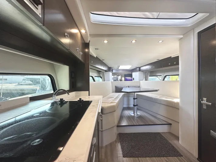 Lux Life Yacht Photos Pics Luxurious interior of 2017 Cruisers Yachts 390 Express Coupe with modern kitchen and seating area.