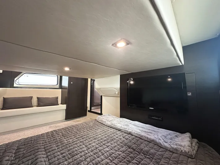 Lux Life Yacht Photos Pics Luxurious interior of 2017 Cruisers Yachts 390 Express Coupe with TV and cozy bedding.