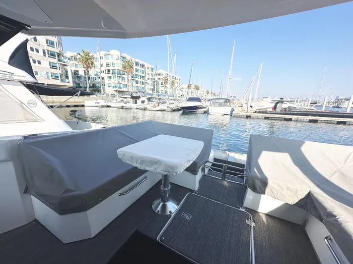Lux Life Yacht Photos Pics 2017 Cruisers Yachts 390 Express Coupe docked at marina, covered seating, and table.
