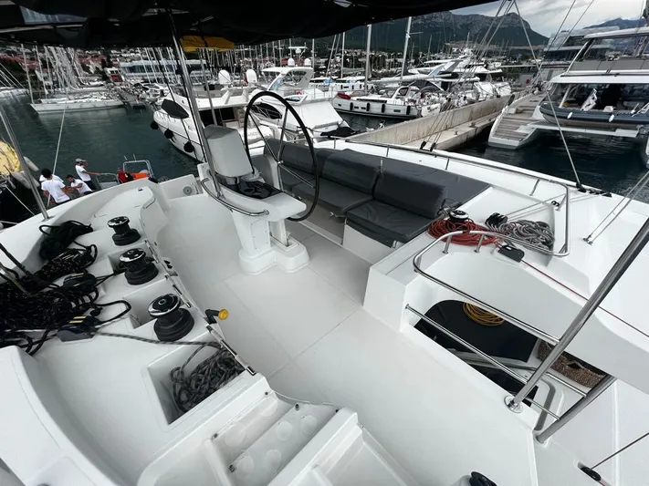  Yacht Photos Pics 2019 Lagoon 52 F yacht cockpit with steering wheel, seating, and marina view.