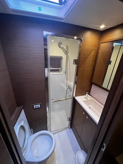  Yacht Photos Pics 2019 Lagoon 52 F yacht bathroom with shower, sink, and toilet. Luxurious wood finish.