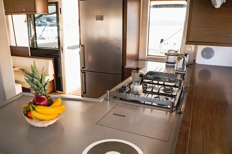  Yacht Photos Pics Modern kitchen interior on 2019 Lagoon 52 F yacht with fruit basket and stainless steel appliances.