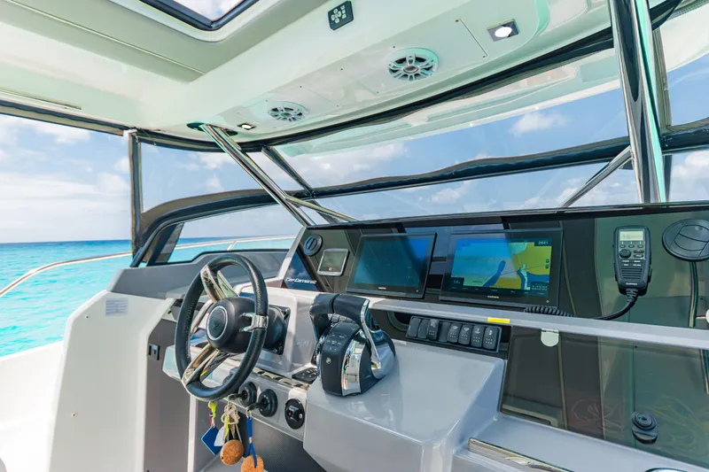  Yacht Photos Pics 2025 Jeanneau Cap Camarat 12.5 WA helm with modern navigation displays and ocean view.