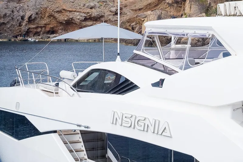 Insignia Yacht Photos Pics Luxury Sunseeker 115 yacht "Insignia" docked by rocky shoreline, 2015 model.