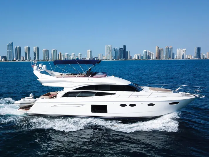  Yacht Photos Pics Luxurious 2013 Princess 60 yacht cruising near a city skyline on a sunny day.