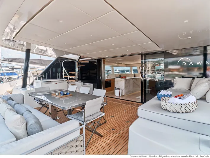 Dawn Yacht Photos Pics Luxurious 2019 Sunreef 60 catamaran with elegant outdoor seating and dining area.