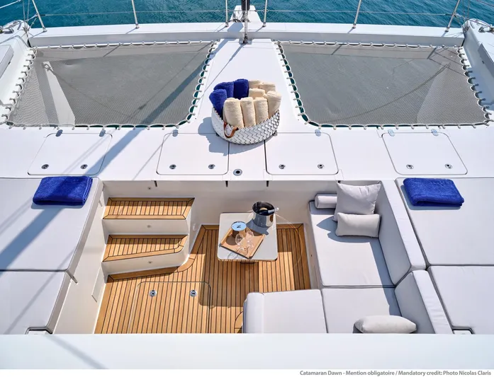 Dawn Yacht Photos Pics Luxurious Sunreef 60 catamaran deck with seating, cushions, and towels, 2019 model.