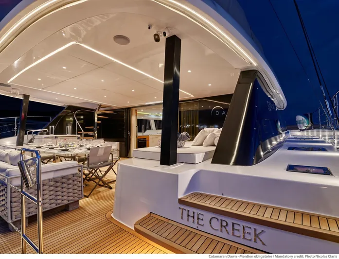 Dawn Yacht Photos Pics Luxurious 2019 Sunreef 60 yacht deck at night, featuring elegant seating and ambient lighting.