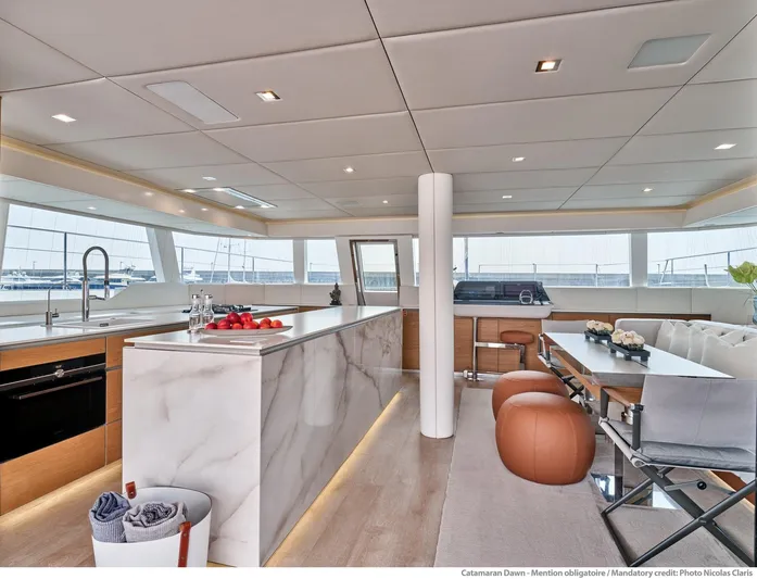 Dawn Yacht Photos Pics Luxurious interior of 2019 Sunreef 60 yacht with modern kitchen and dining area.