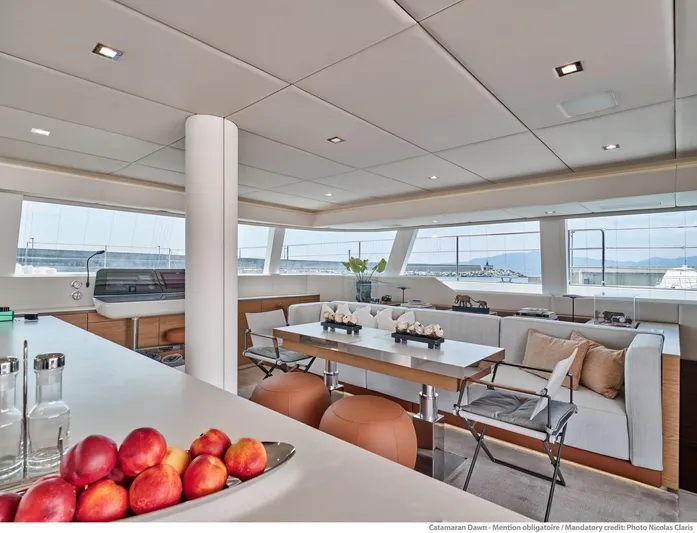 Dawn Yacht Photos Pics Luxurious interior of 2019 Sunreef 60 yacht with modern seating and panoramic windows.