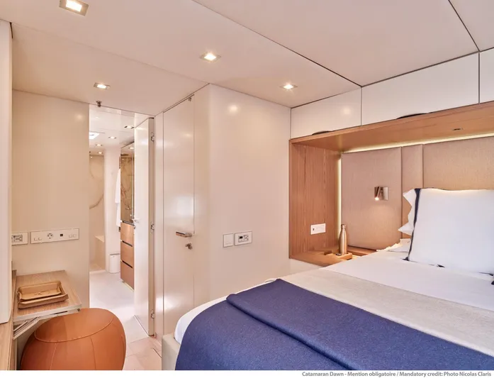 Dawn Yacht Photos Pics Luxurious interior of 2019 Sunreef 60 yacht, featuring a modern bedroom and ensuite bathroom.