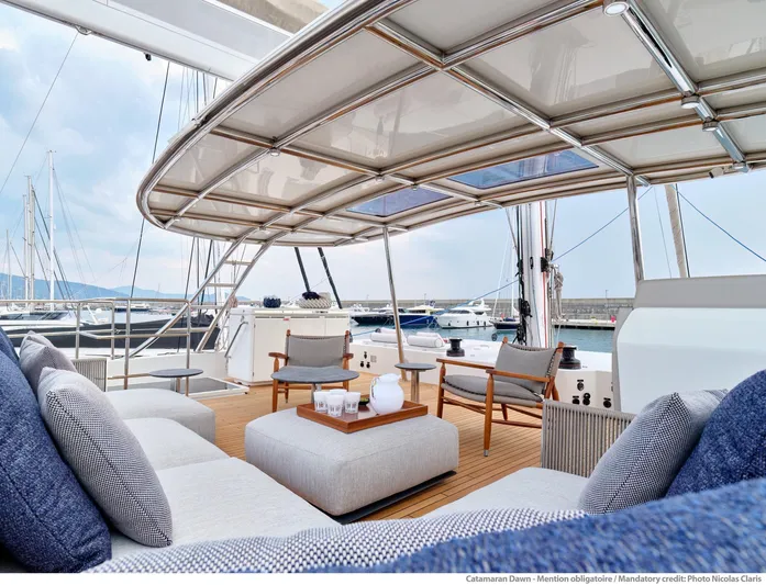 Dawn Yacht Photos Pics Luxurious Sunreef 60 catamaran deck with elegant seating, 2019 model, docked at marina.