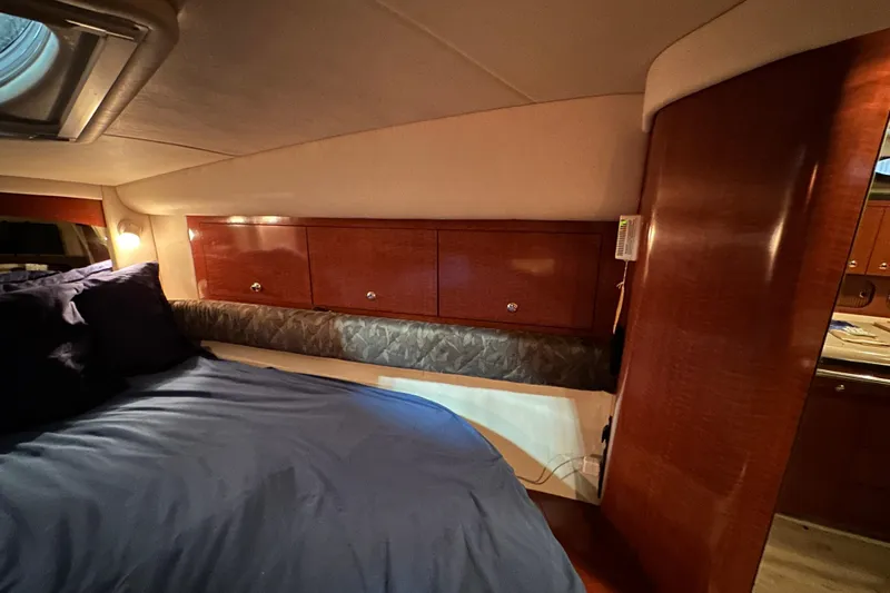  Yacht Photos Pics Luxurious cabin interior of 2004 Sea Ray 340 Sundancer with wood paneling and cozy bedding.
