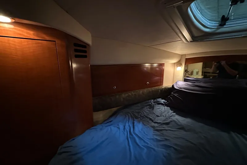  Yacht Photos Pics Interior cabin of 2004 Sea Ray 340 Sundancer with wood paneling and cozy bedding.