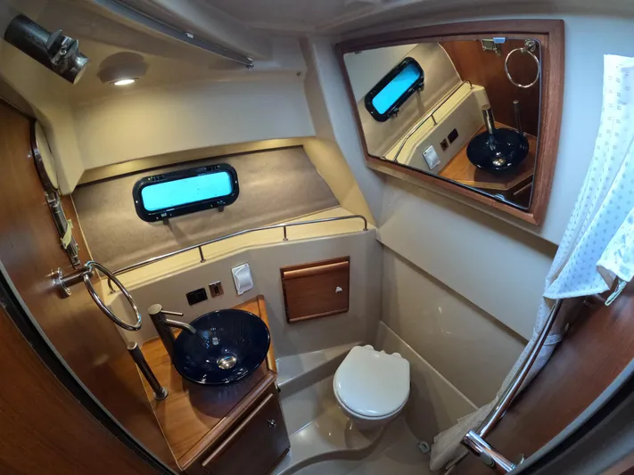  Yacht Photos Pics 2020 Ranger Tugs R-27 boat bathroom with modern sink, mirror, and porthole window.