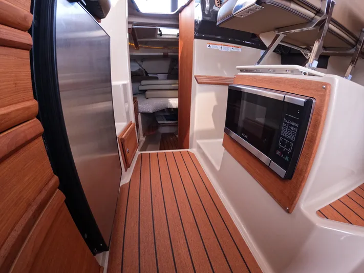  Yacht Photos Pics 2020 Ranger Tugs R-27 interior with wood flooring, microwave, and compact kitchen area.