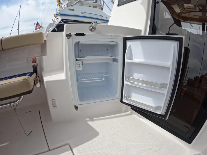  Yacht Photos Pics Open mini fridge on 2020 Ranger Tugs R-27 boat deck, showcasing interior storage space.
