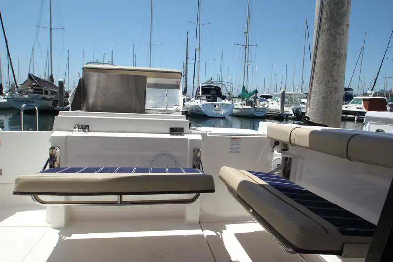  Yacht Photos Pics 2020 Ranger Tugs R-27 boat interior with seating, docked at a marina with sailboats.