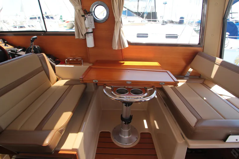  Yacht Photos Pics Interior of 2020 Ranger Tugs R-27 with seating and wooden table.