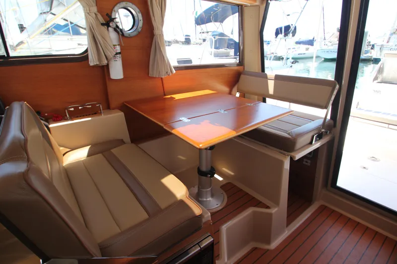  Yacht Photos Pics 2020 Ranger Tugs R-27 interior with dining area, wooden table, and cushioned seating.