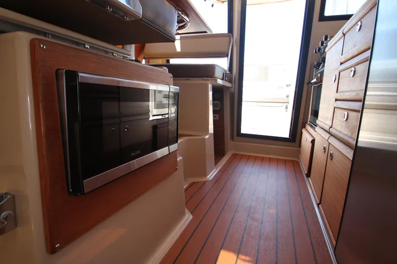  Yacht Photos Pics 2020 Ranger Tugs R-27 interior with wood flooring and modern kitchen appliances.