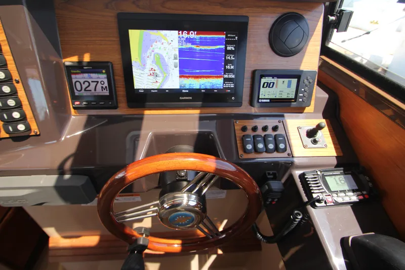  Yacht Photos Pics 2020 Ranger Tugs R-27 helm with navigation screens and wooden steering wheel.