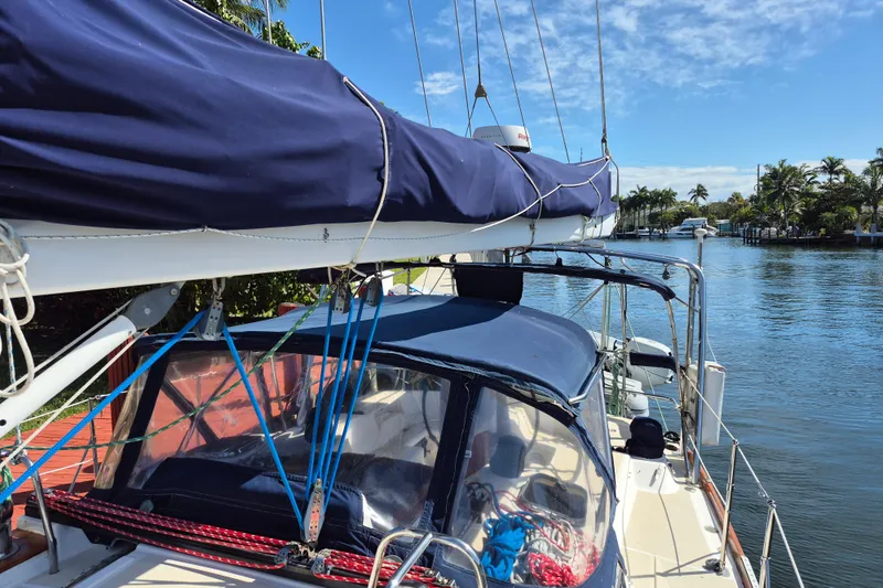 R'liberty Yacht Photos Pics Sailboat Tartan 3700 (2001) docked by a scenic waterway with clear skies.