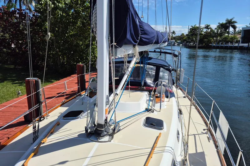 R'liberty Yacht Photos Pics Sailboat docked by a canal, Tartan 3700 model, 2001, with lush greenery and clear skies.